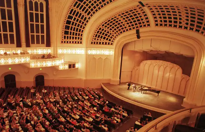 Large historic auditorium filled with audience.