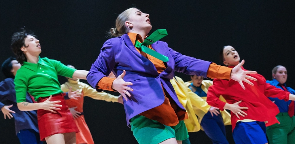 Dancers in brightly colored clothing striking a pose