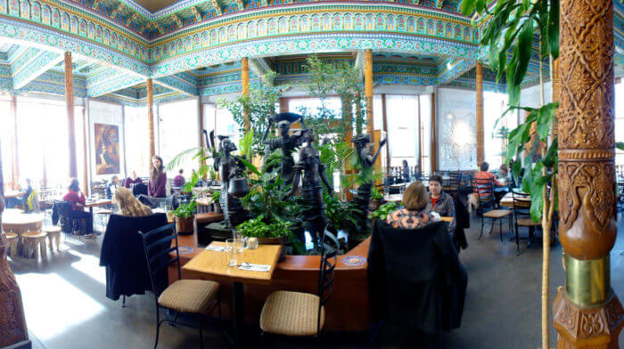 Fisheye shot of restaurant with greenery and elaborate walls.
