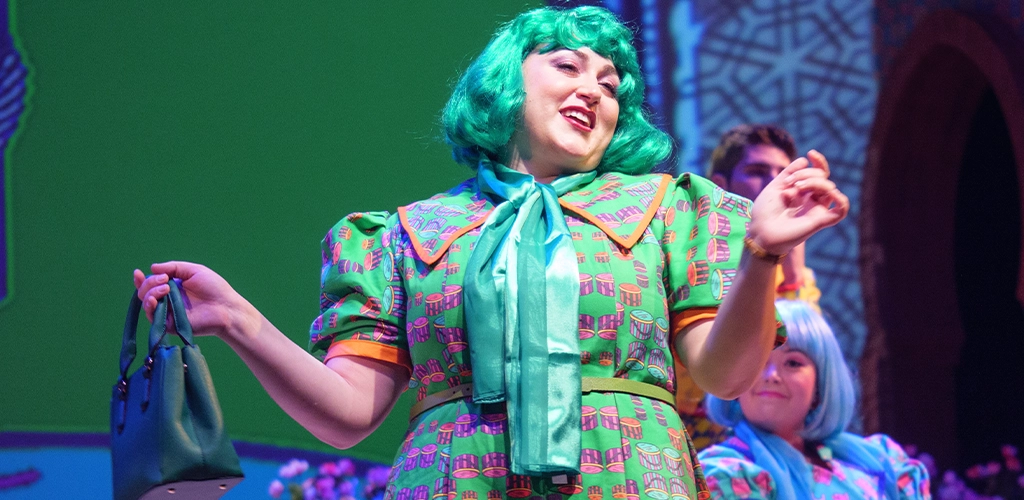 Woman on stage in green dress with green hair